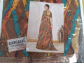 A packaged Gangajal full saree lace by Satvacha, featuring a colorful abstract pattern in brown, teal, orange, and gold. A central printed card shows a model wearing a saree made from the fabric, and a white label on the lower left reads 'GANGAJAL FULL SAREE LACE' with the Satvacha brand.